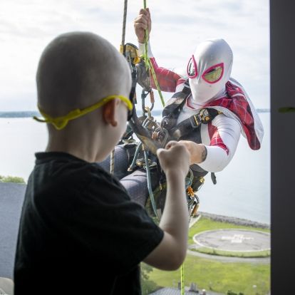 Image of a superhero window washer with child at window