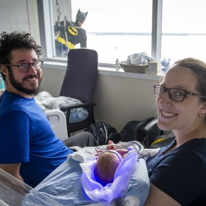 Image of a superhero window washer with family on peds
