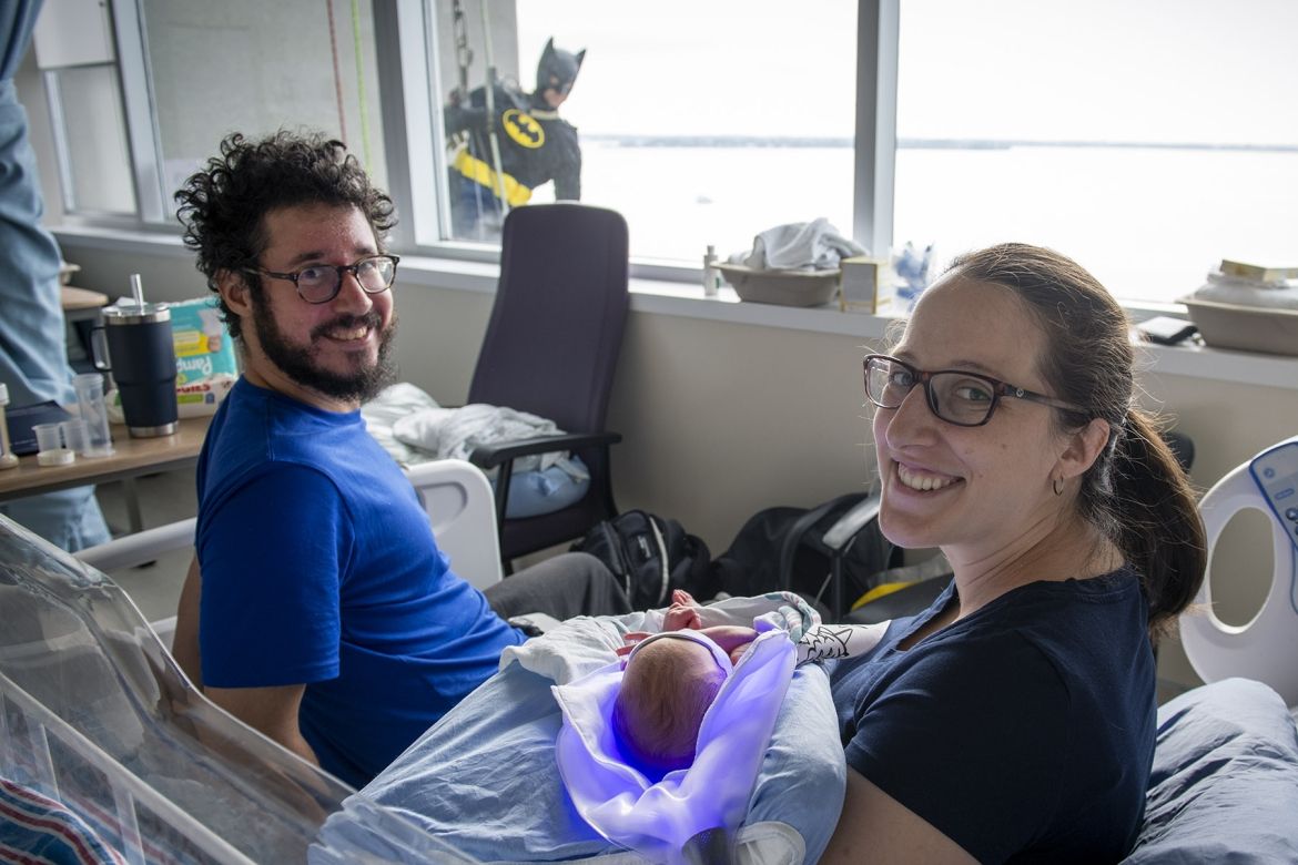 Image of a superhero window washer with family on peds