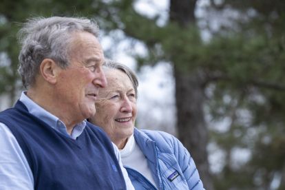 Graham and Maureen Rush sitting on a bench in a park looking forward.