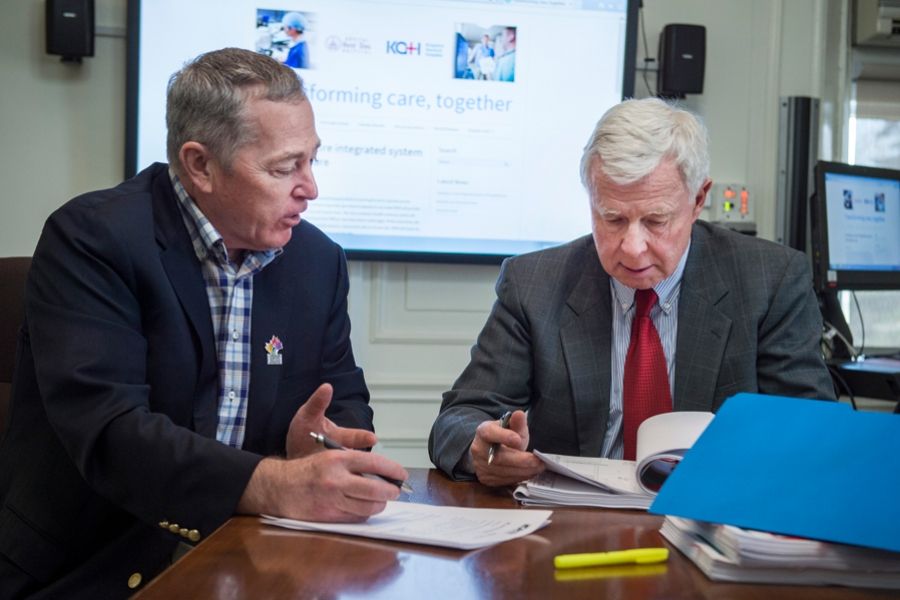 Jim Flett and George Thomson review some documents in the board room.